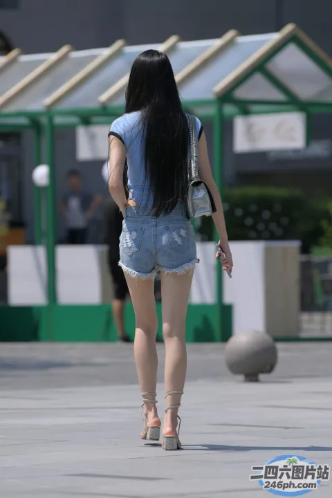 阿拉菲德女人提着背包和手机走在人行道上