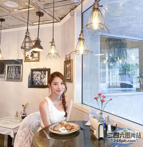 有个女人坐在一张桌子旁，桌上放着一盘食物