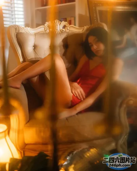 沙发上坐着一个穿着红色连衣裙的女人