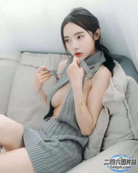 一个穿着灰色连衣裙的女人坐在沙发上