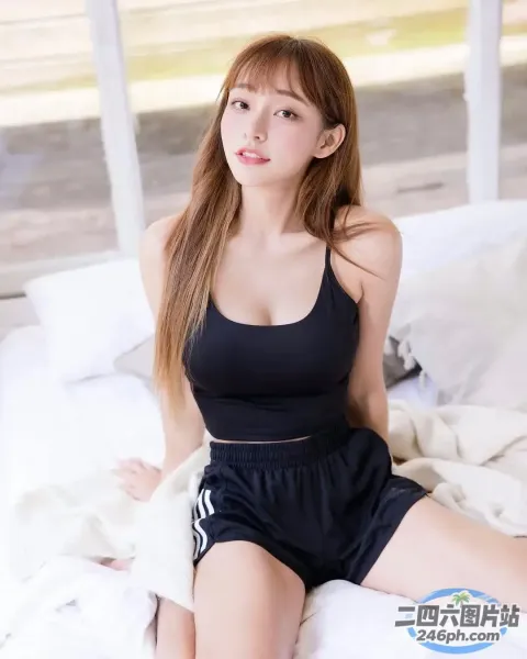 一个穿着黑色上衣坐在床上的女人的特写