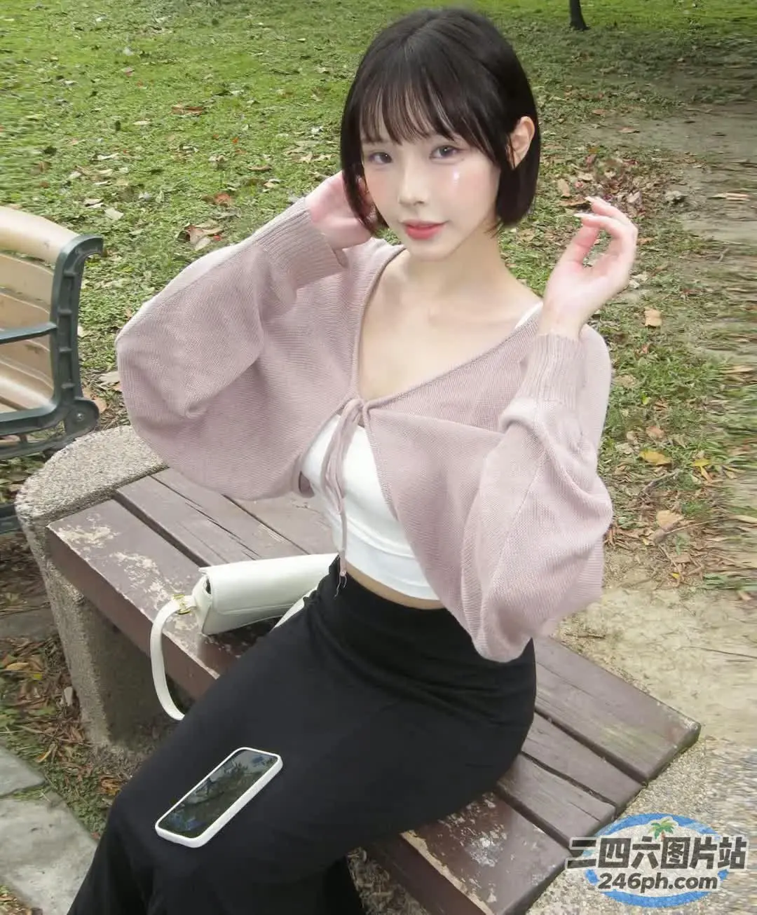 有个女人坐在长凳上，手里拿着手机