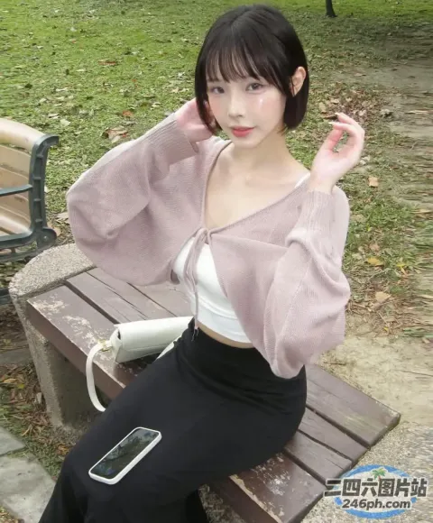 有个女人坐在长凳上，手里拿着手机
