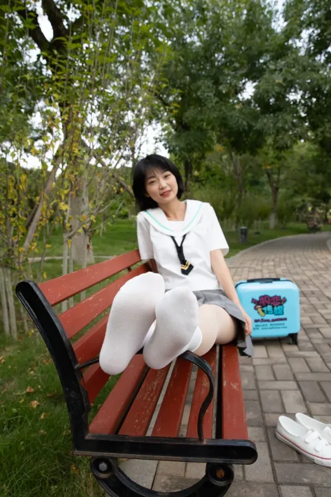 有个女人坐在长凳上，双腿交叉