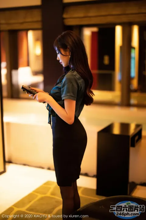 身穿黑色连衣裙的 Araffe 女子看手机
