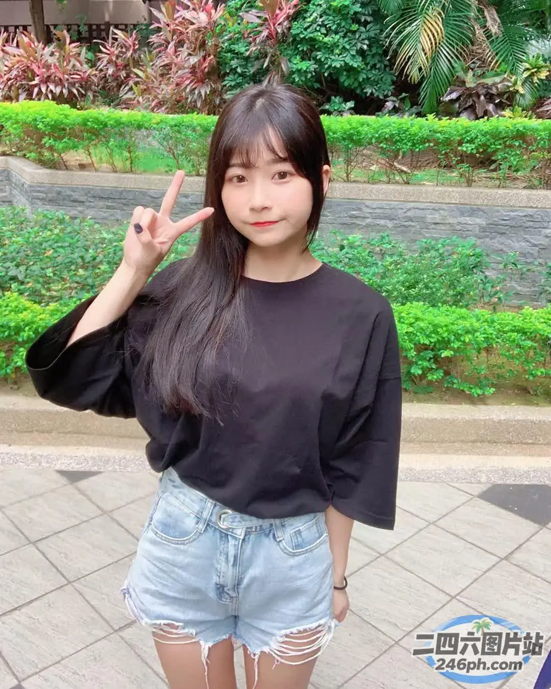 身穿黑色衬衫和牛仔短裤的 arafed 亚洲女性合影留念