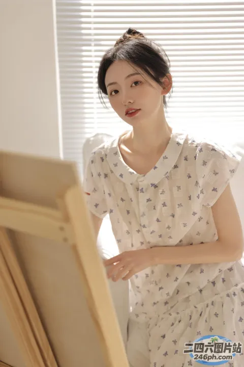 画架前站着一个女人，画架上放着一幅画