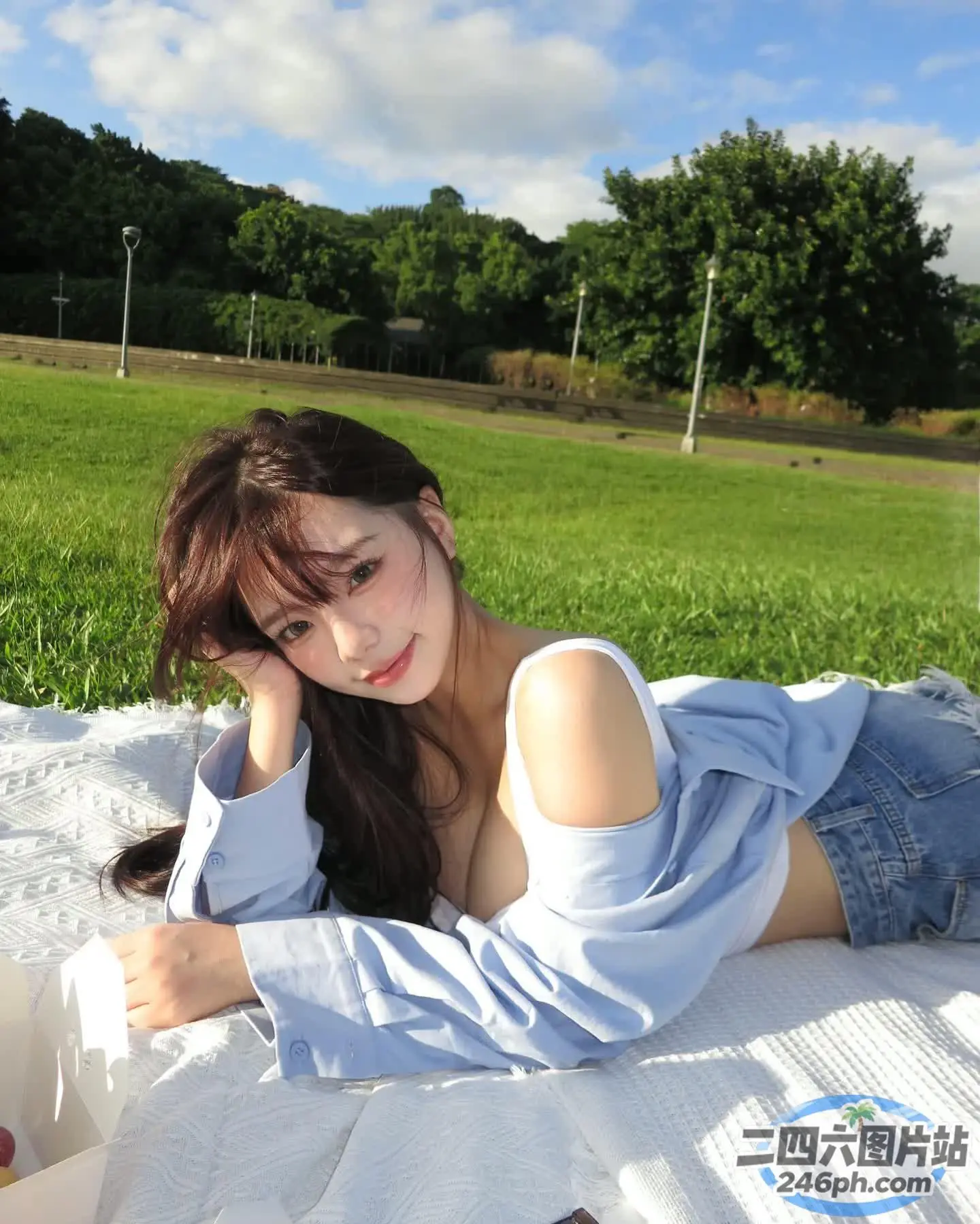 阿拉伯女人躺在公园的毯子上，手里拿着一本书