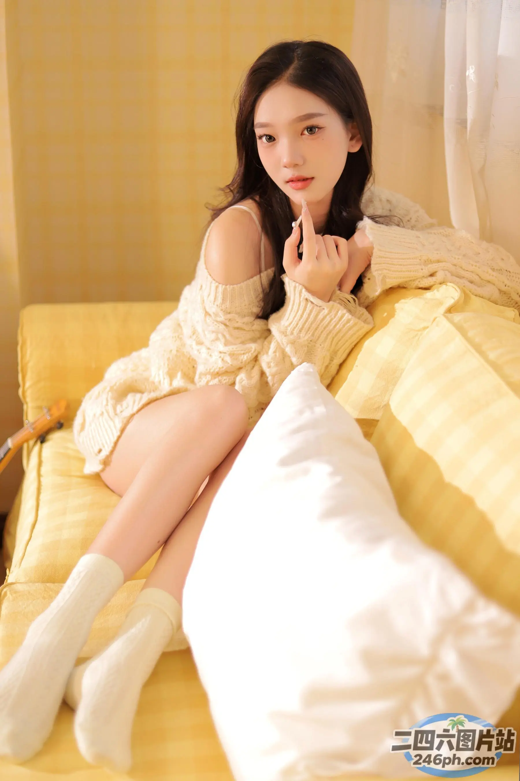 阿拉菲女人坐在床上，盖着一条黄色的毯子