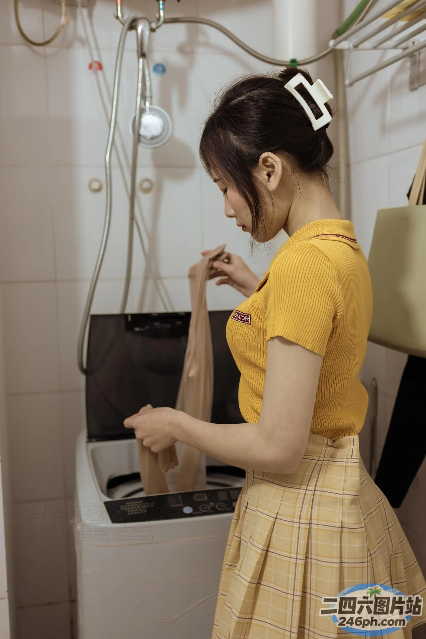 身穿黄色衬衫和裙子的 araffe 女子站在洗衣机前