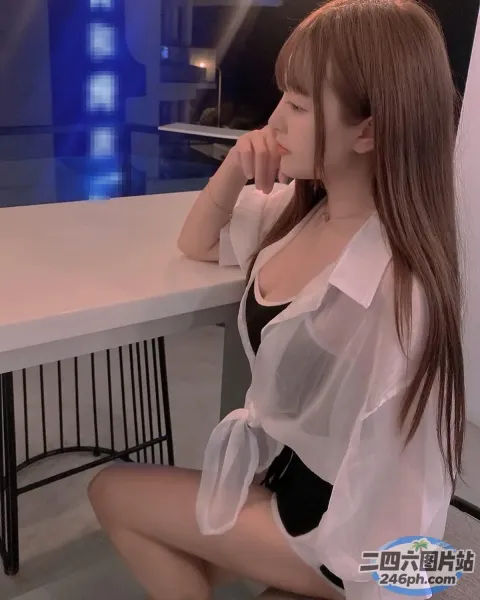 阿拉菲女子坐在桌子旁，膝盖上放着一台笔记本电脑