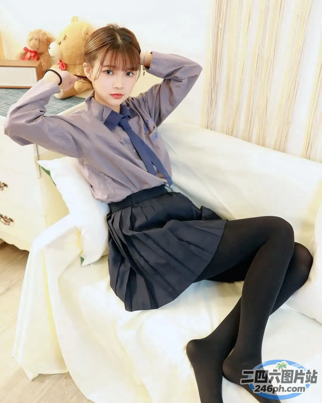 有个女人坐在沙发上，手里拿着一只泰迪熊