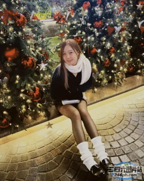 有个女人坐在圣诞树前的长凳上
