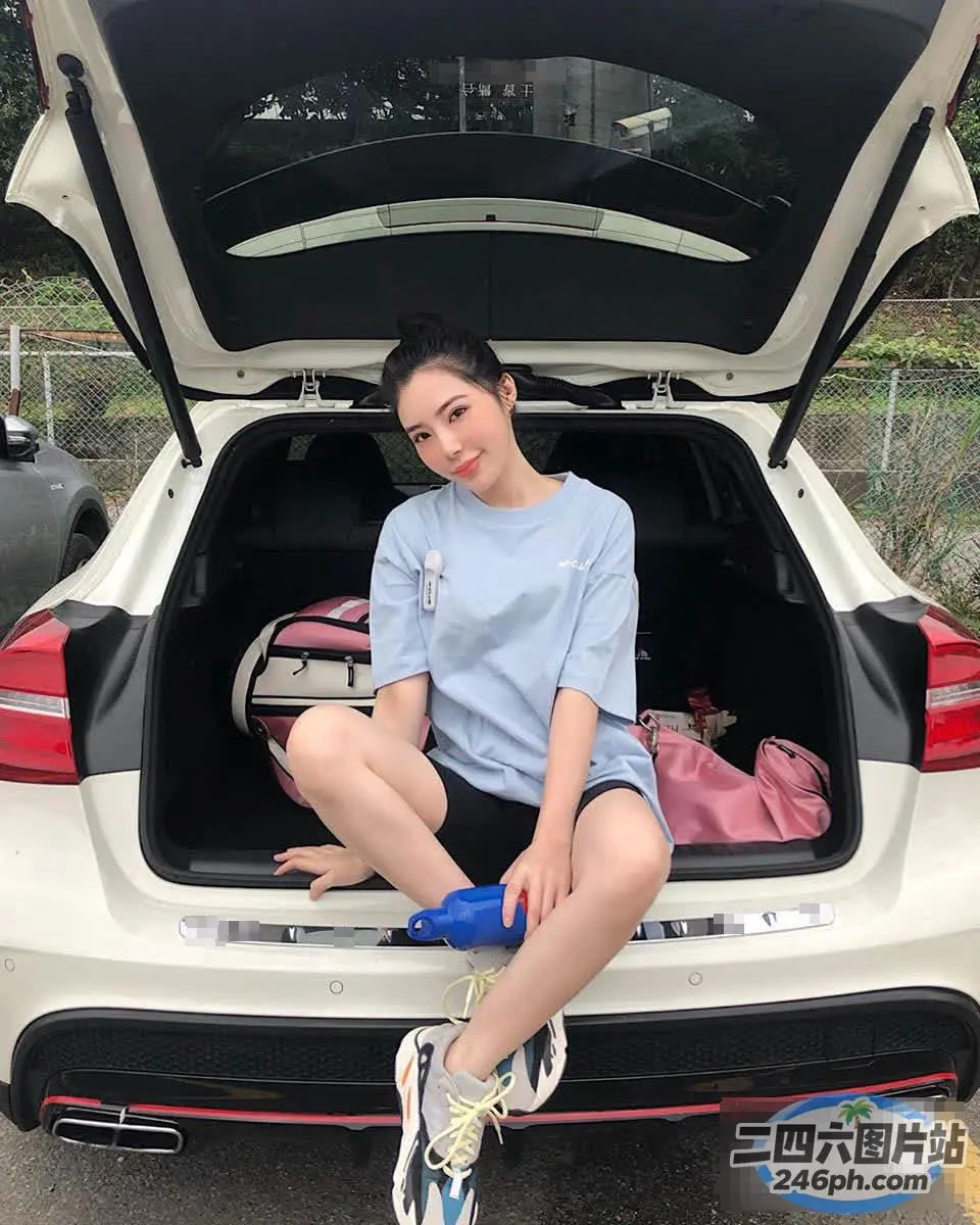 阿拉菲坐在汽车后备箱里，里面装着一个袋子