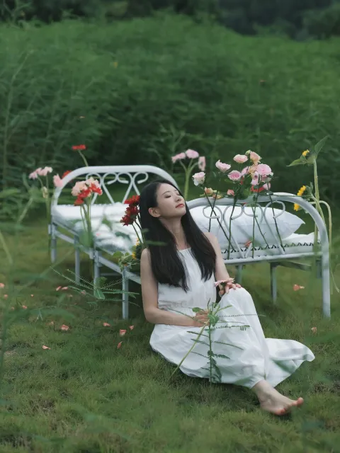 草地上的长凳上坐着一个女人
