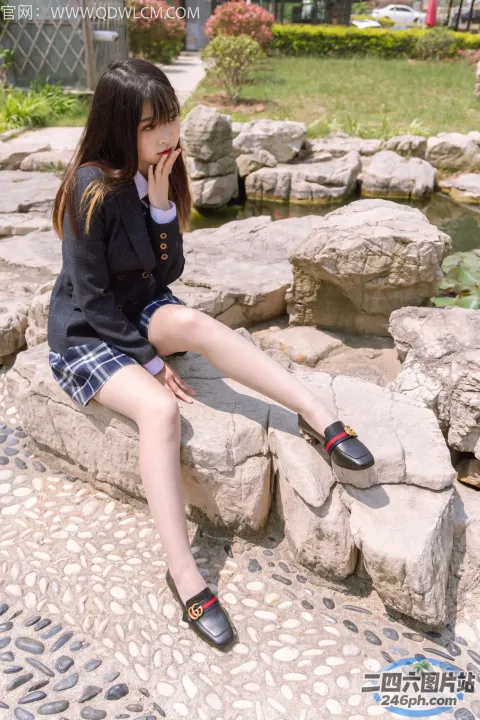 坐在公园岩石上的 arafed 亚洲女孩