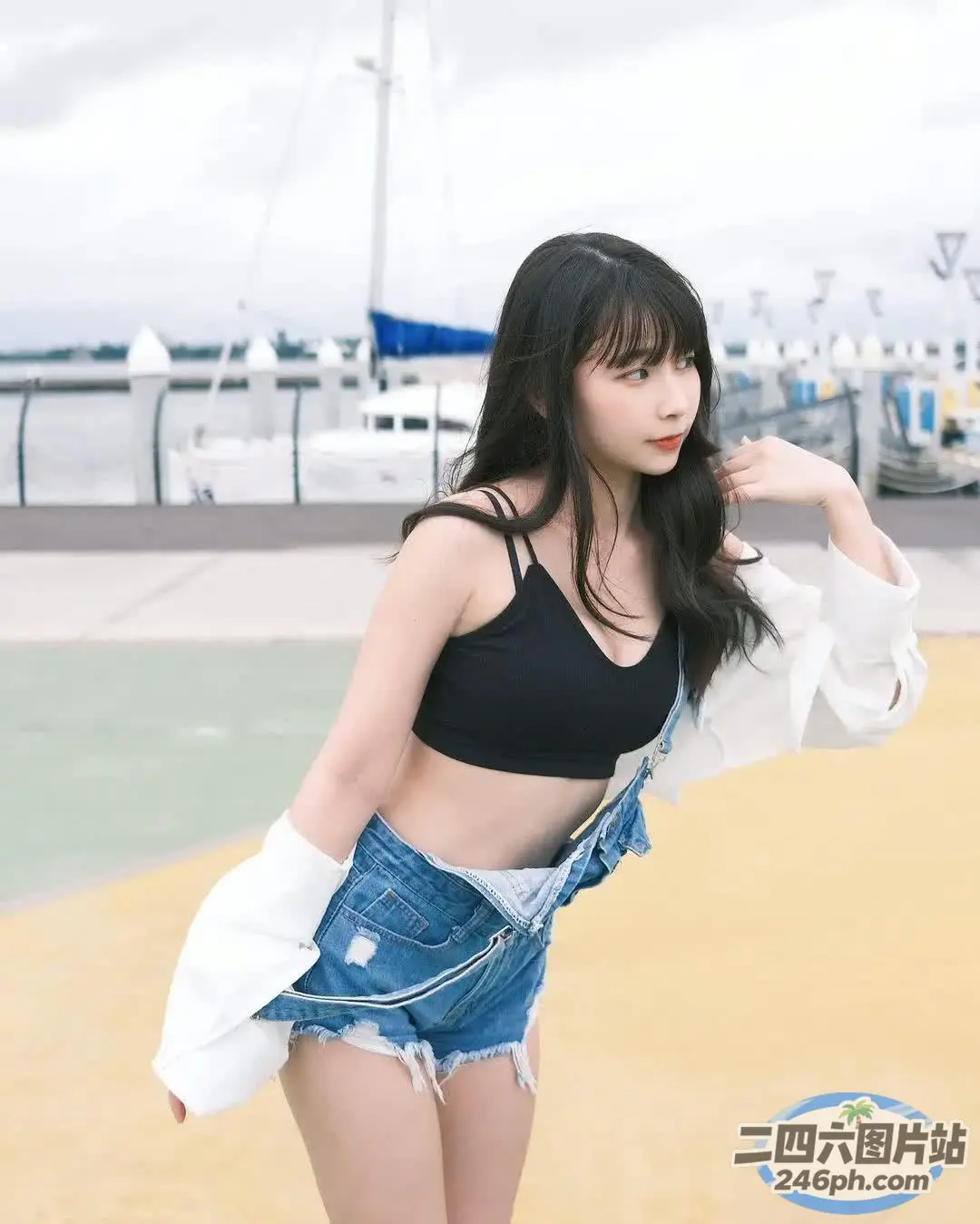 一位身穿黑色上衣和牛仔短裤的女士摆姿势拍照