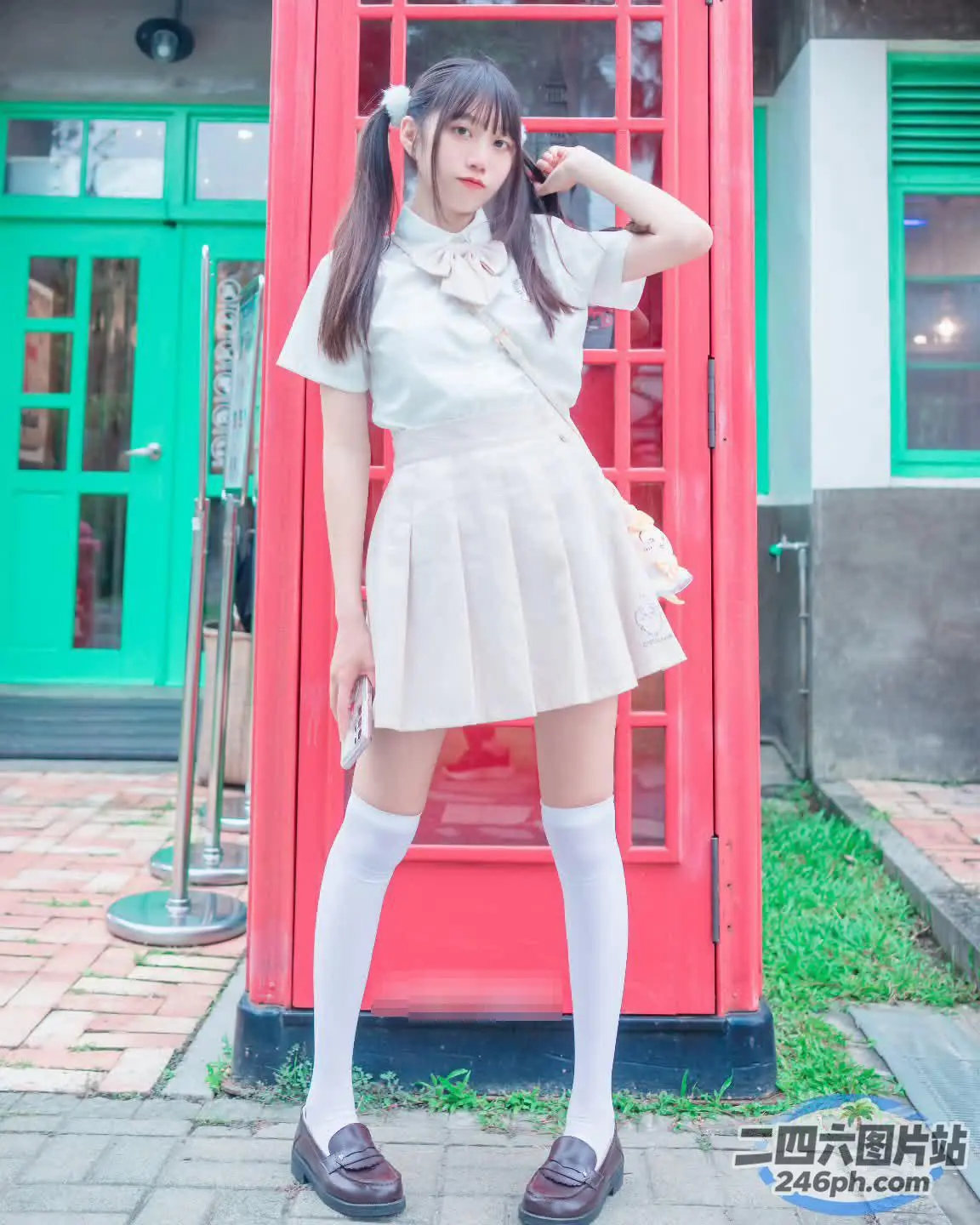 红色电话亭前站着一名女子