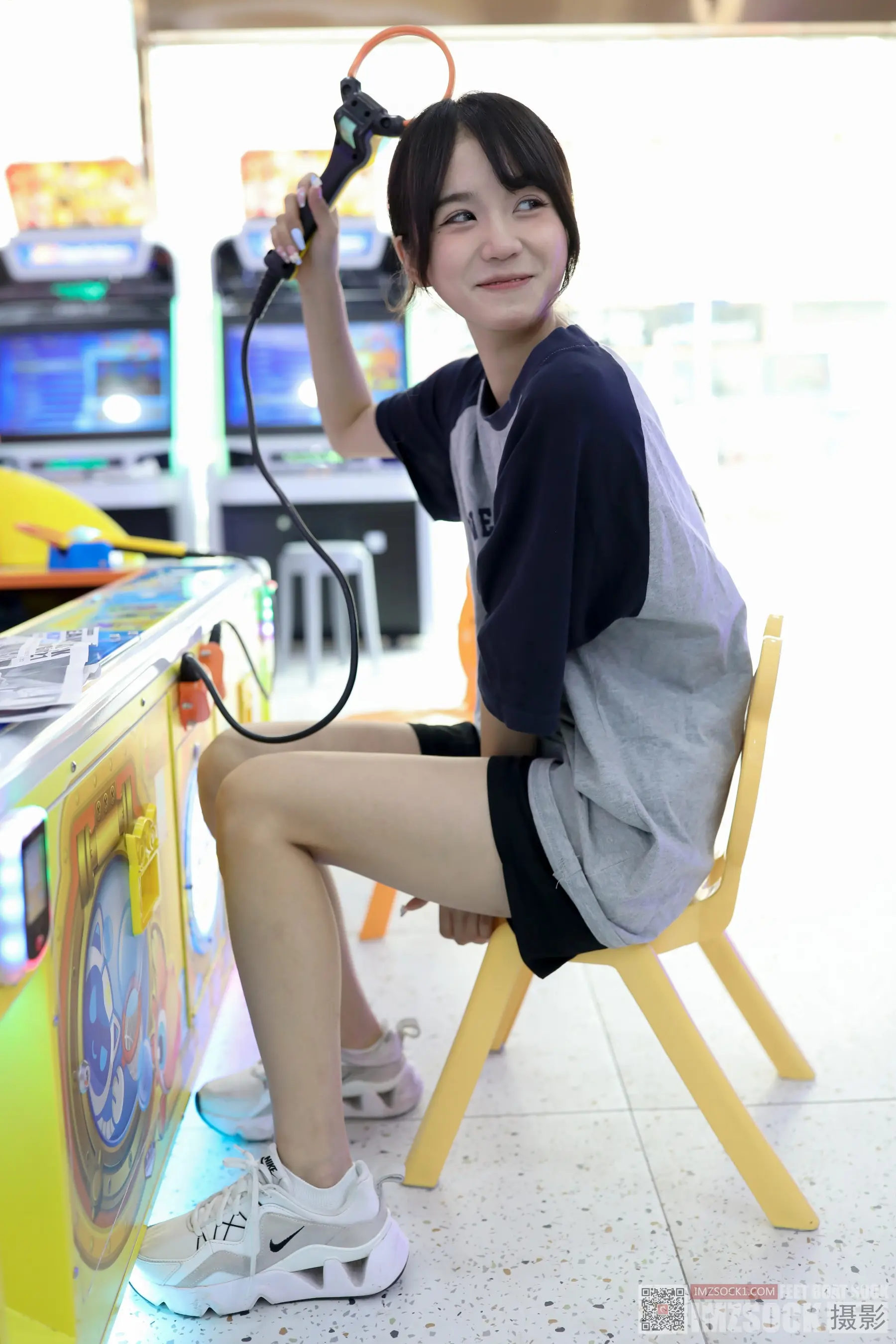 有个女人坐在椅子上，手里拿着吹风机