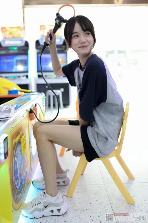 有个女人坐在椅子上，手里拿着吹风机