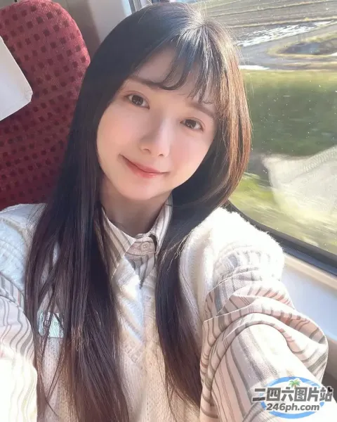 长发的 Araffe 女人坐在火车上看着镜头