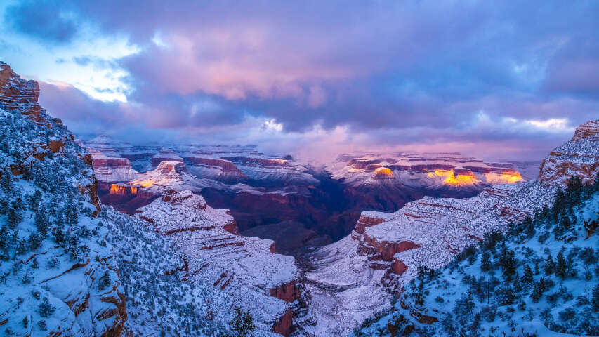 峡谷的雪景，背景是日落