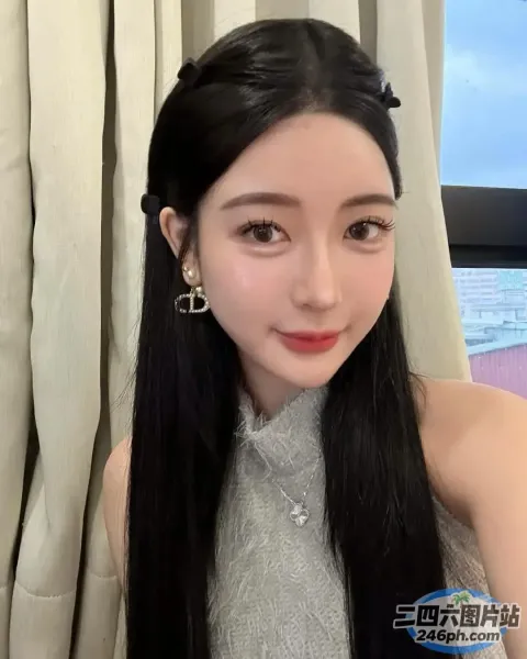 一位黑发女子，身穿灰色上衣，戴着耳环