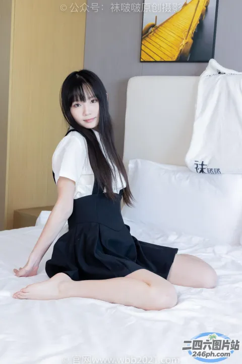 穿着黑色连衣裙坐在床上的 arafed 亚洲女性