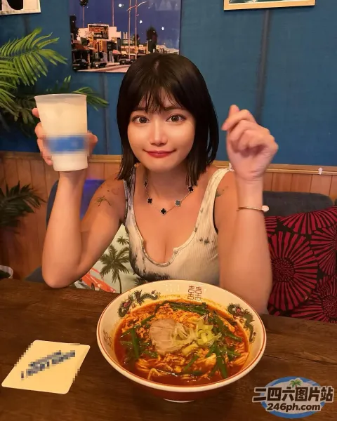 女人坐在桌子旁，手里拿着一碗汤和一杯饮料