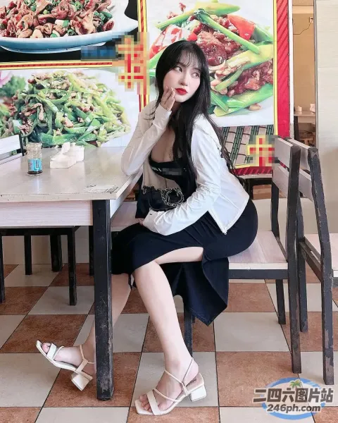 有个女人坐在一张桌子旁，桌上放着一盘食物