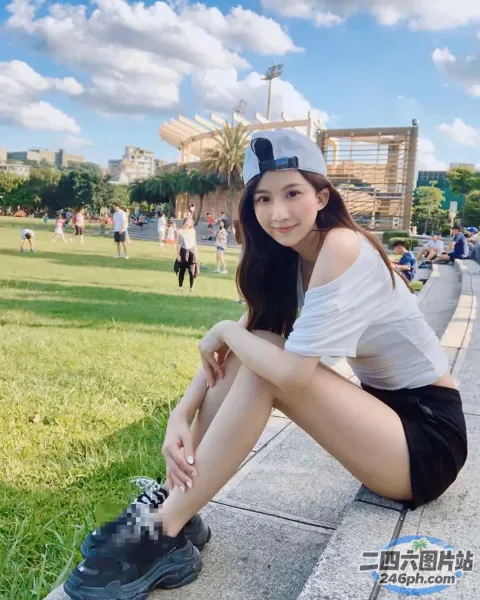 一名戴着帽子坐在公园路边的女人