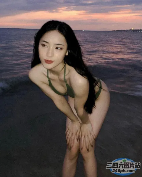 有个身穿比基尼的女人在沙滩上摆姿势