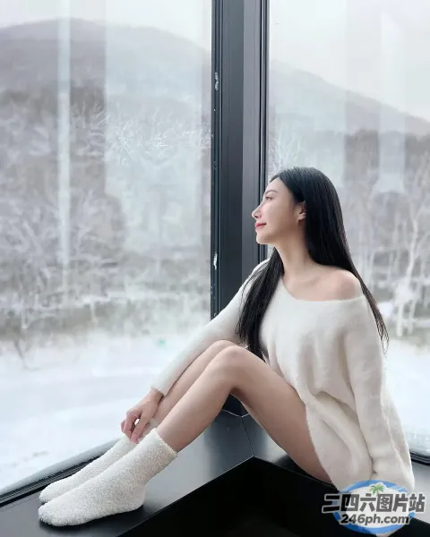 一个女人坐在窗台上望向窗外