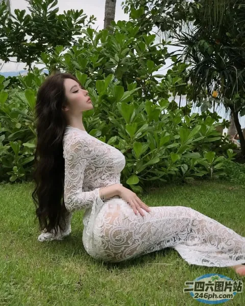 穿着白色连衣裙坐在草地上的 Araffe 女子