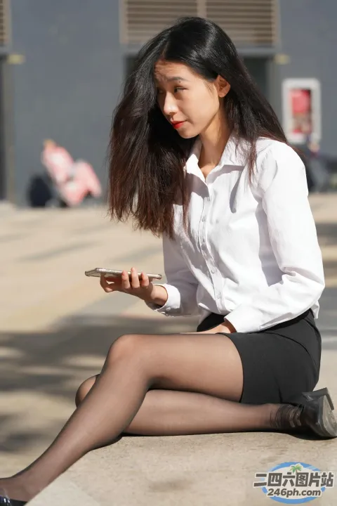 阿拉菲女子坐在地上用手机