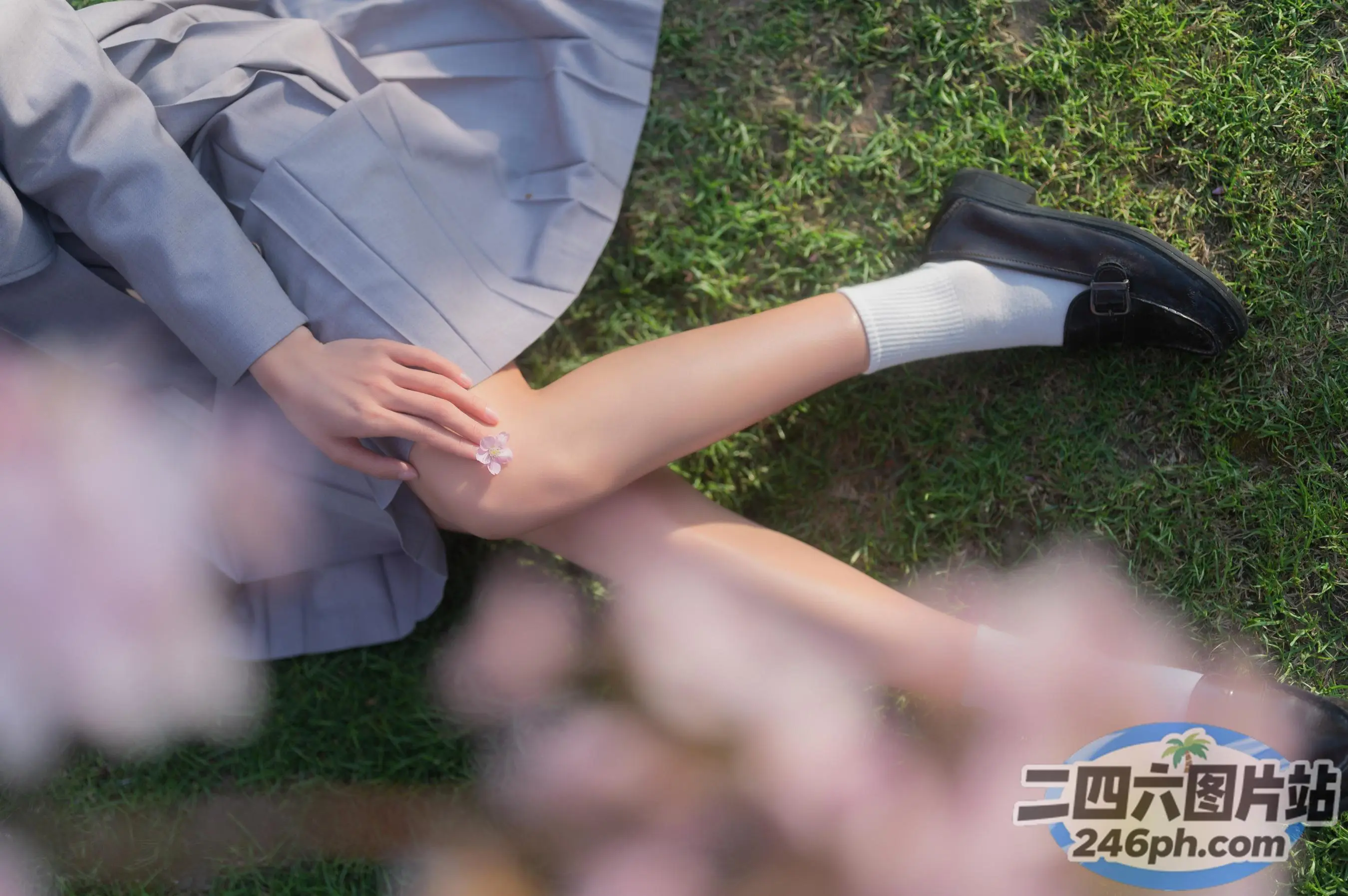 有一个穿着裙子和鞋子的女人躺在草地上