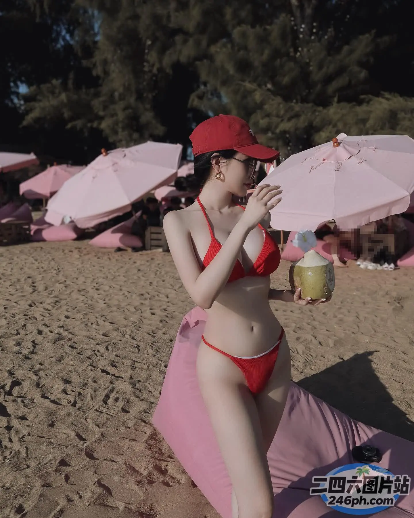 海滩上有一个穿着比基尼、戴帽子的女人