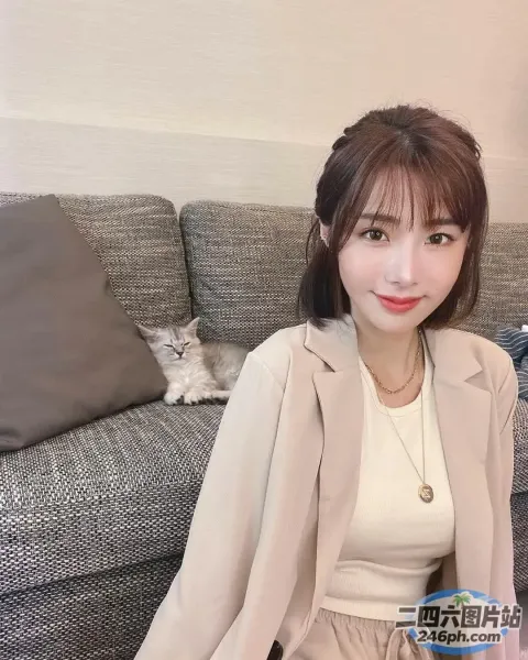 阿拉夫德女人坐在沙发上，手里拿着一本书和一只猫