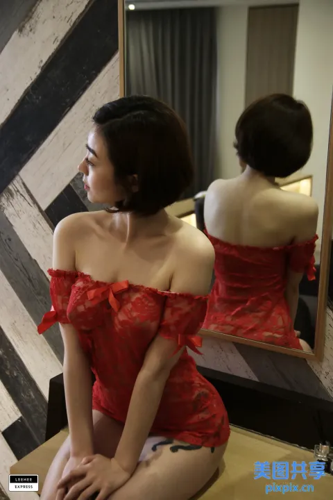 一位身穿红色连衣裙的女人坐在凳子上的特写