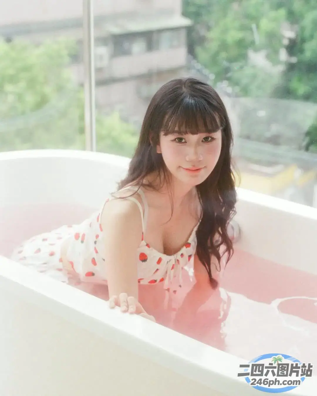 粉红色背景的浴缸里的 araffe 亚洲女人