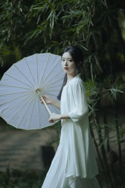 公园里拿着白色雨伞的阿拉伯女子