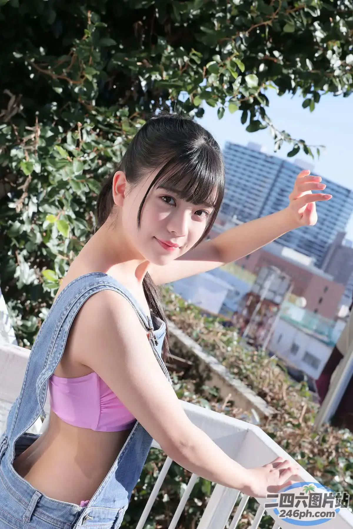 身穿粉红色上衣和牛仔工作服的 araffe 亚洲女性合影留念