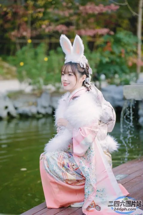 木凳上坐着一个穿着粉红色连衣裙的女人