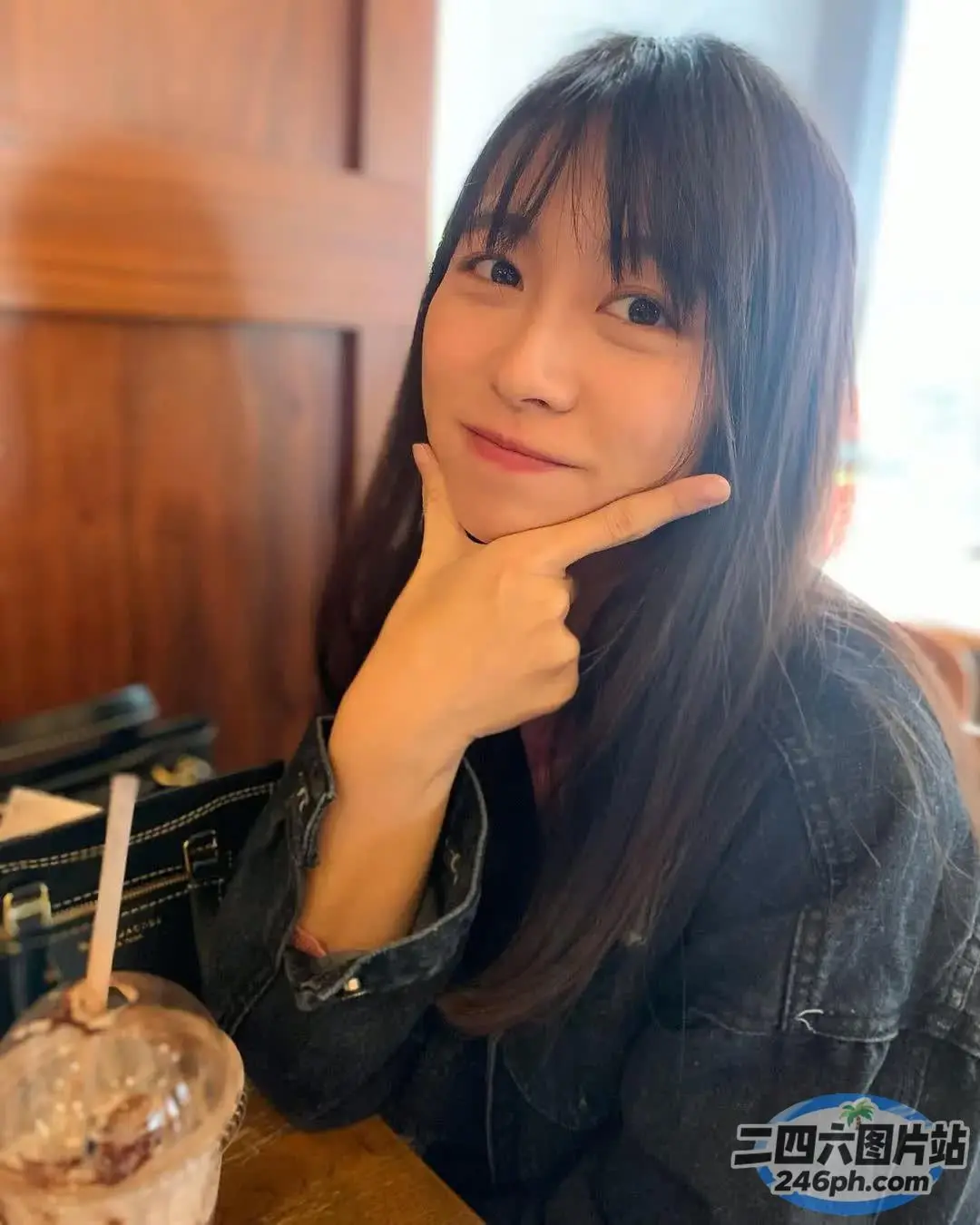 阿拉夫德女人坐在桌子旁，手里拿着饮料和吸管