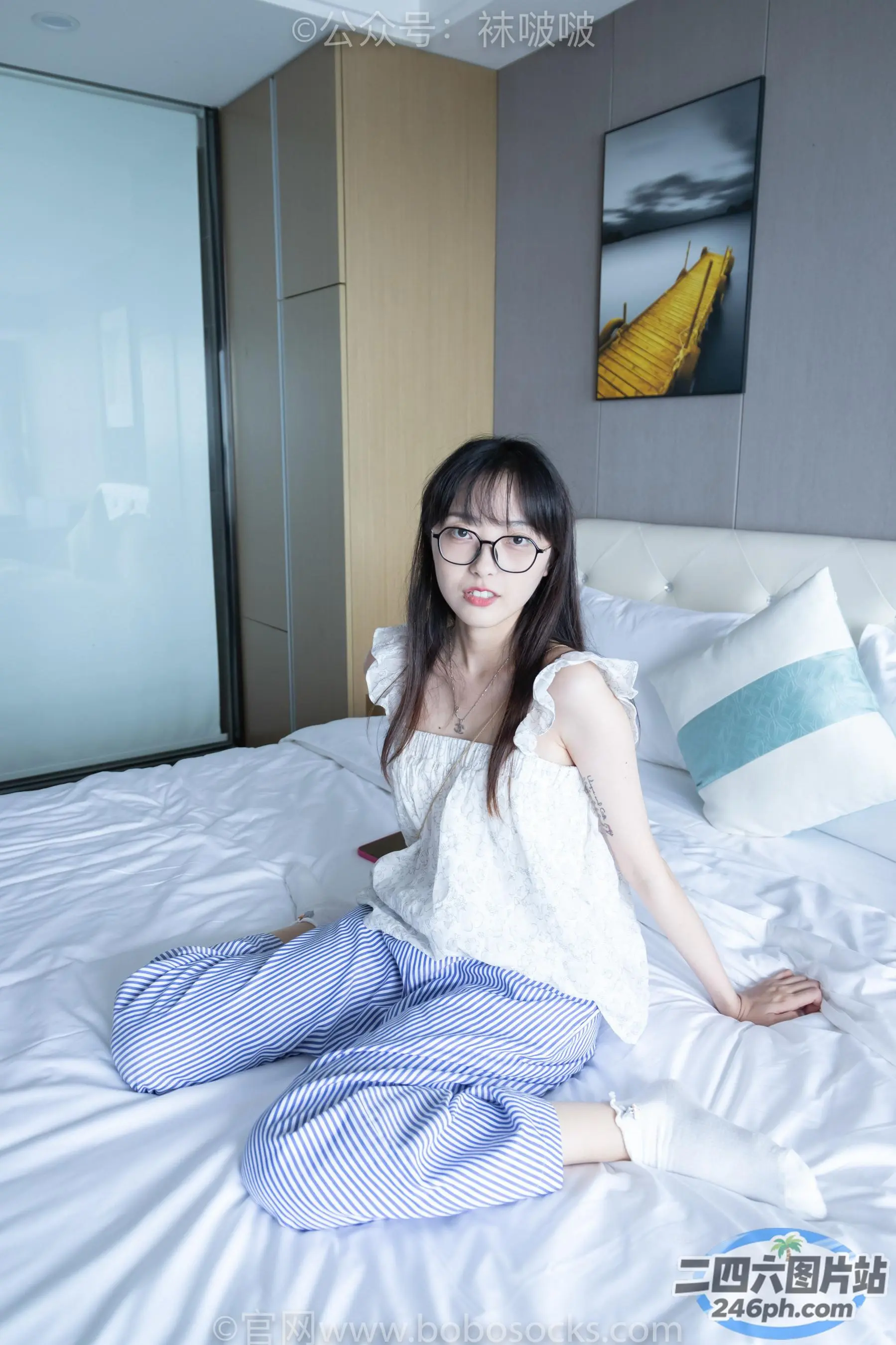 阿拉菲德女人坐在铺着白色被子的床上