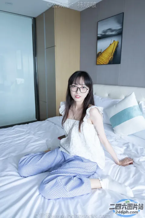 阿拉菲德女人坐在铺着白色被子的床上