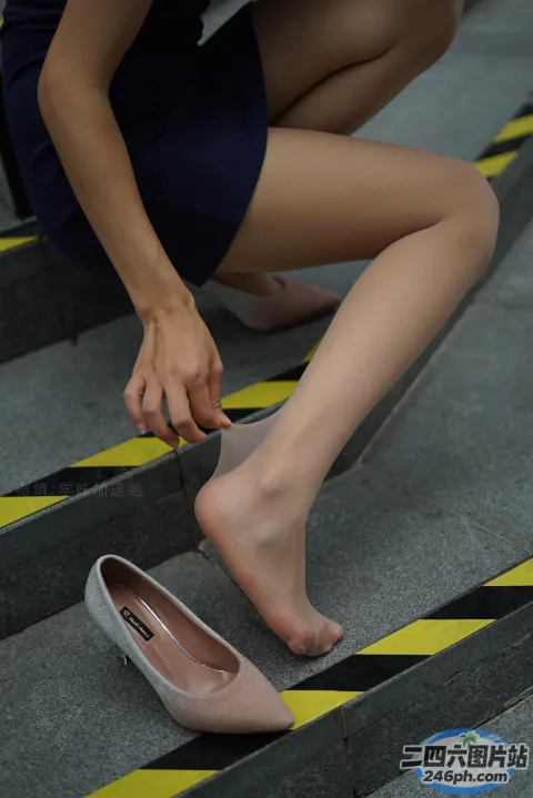身穿蓝色连衣裙的 Araffes 女子在楼梯上系鞋带