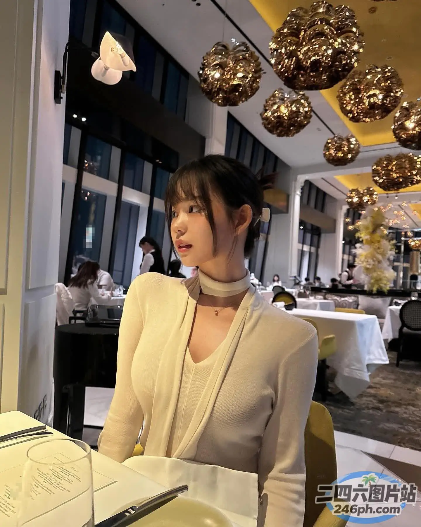 有个女人坐在一张桌子旁，桌上放着一盘食物