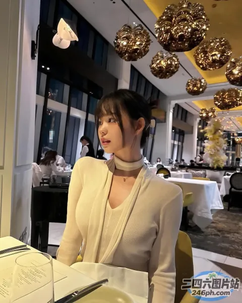 有个女人坐在一张桌子旁，桌上放着一盘食物