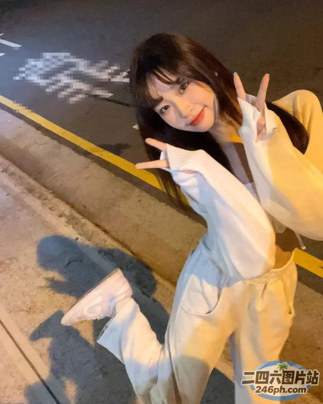 有个女人站在街边，打着和平的手势